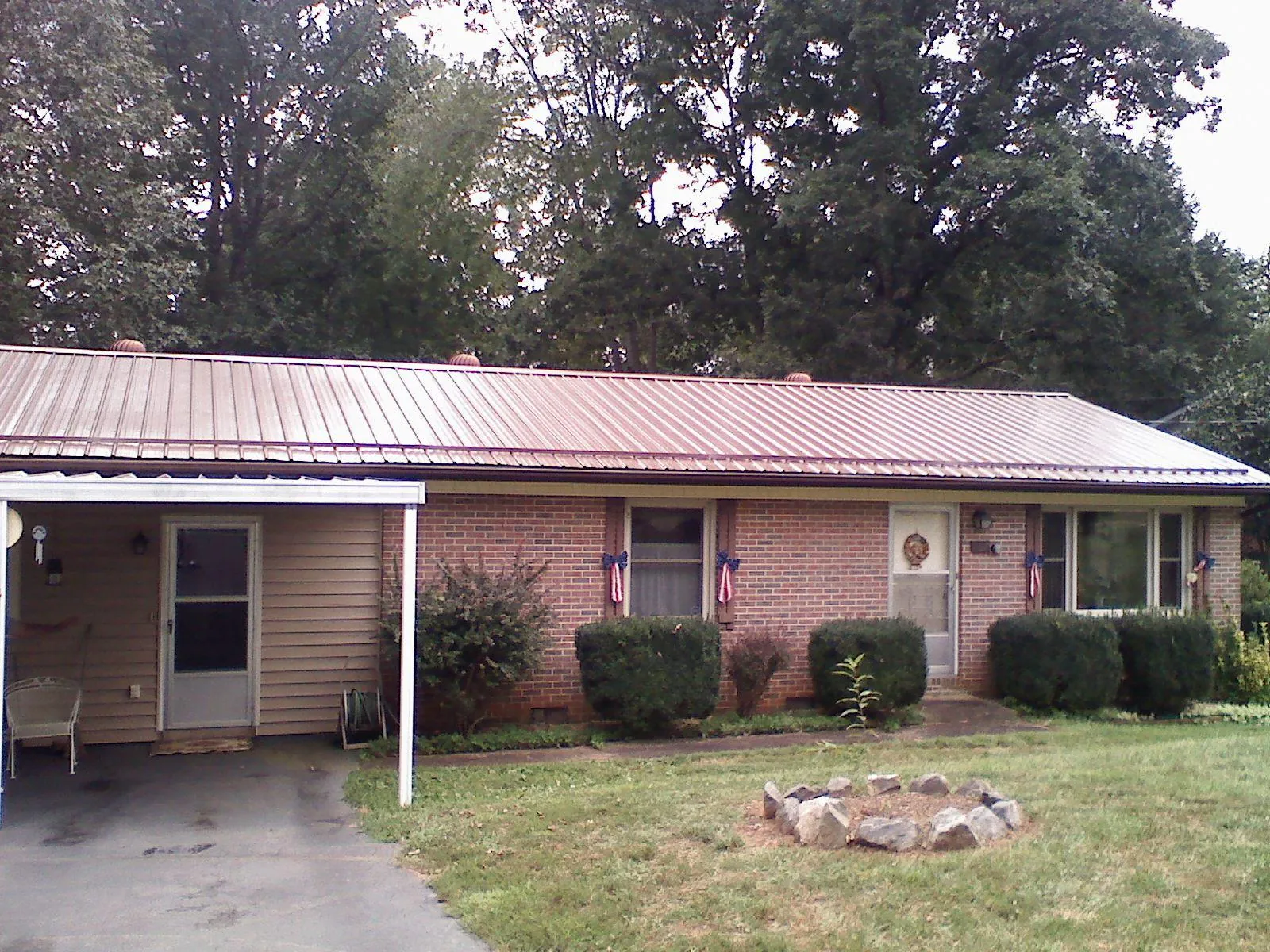Bronze metal roof and carport on a brick ranch home — Roof Repair work by our crew in Oquawka